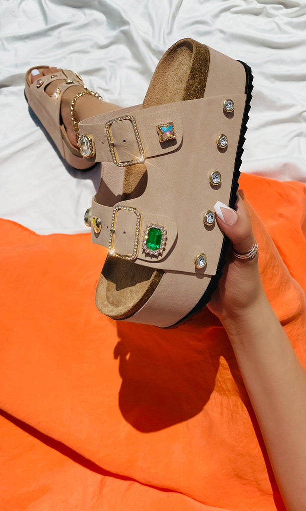 CHELSEA MODELO LLEVA VESTIDO NARANJA MIENTRAS SOSTIENE SANDALIA NUDE DE PLATAFORMA WEDGE CON PEDRERIA Y PULSERAS TOBILLERAS 