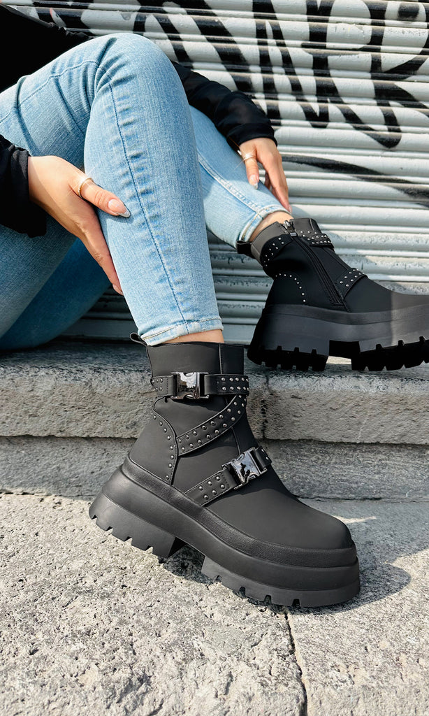 FORCE COMBAT BOOTS DE MODA CON HEBILLAS GRANDES PARA USAR CON JEANS AJUSTADOS Y BLUSA NEGRA EN UN LOOK CASUAL